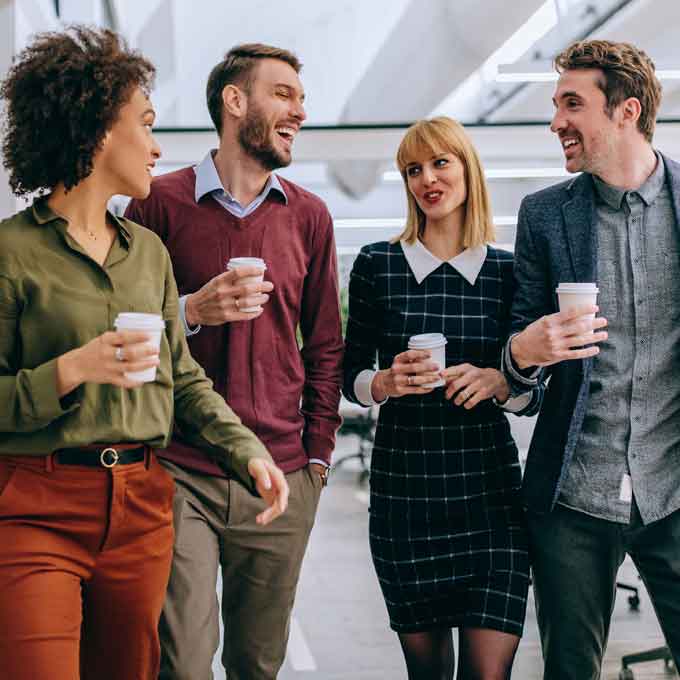 Office group laughing and enjoying coffee